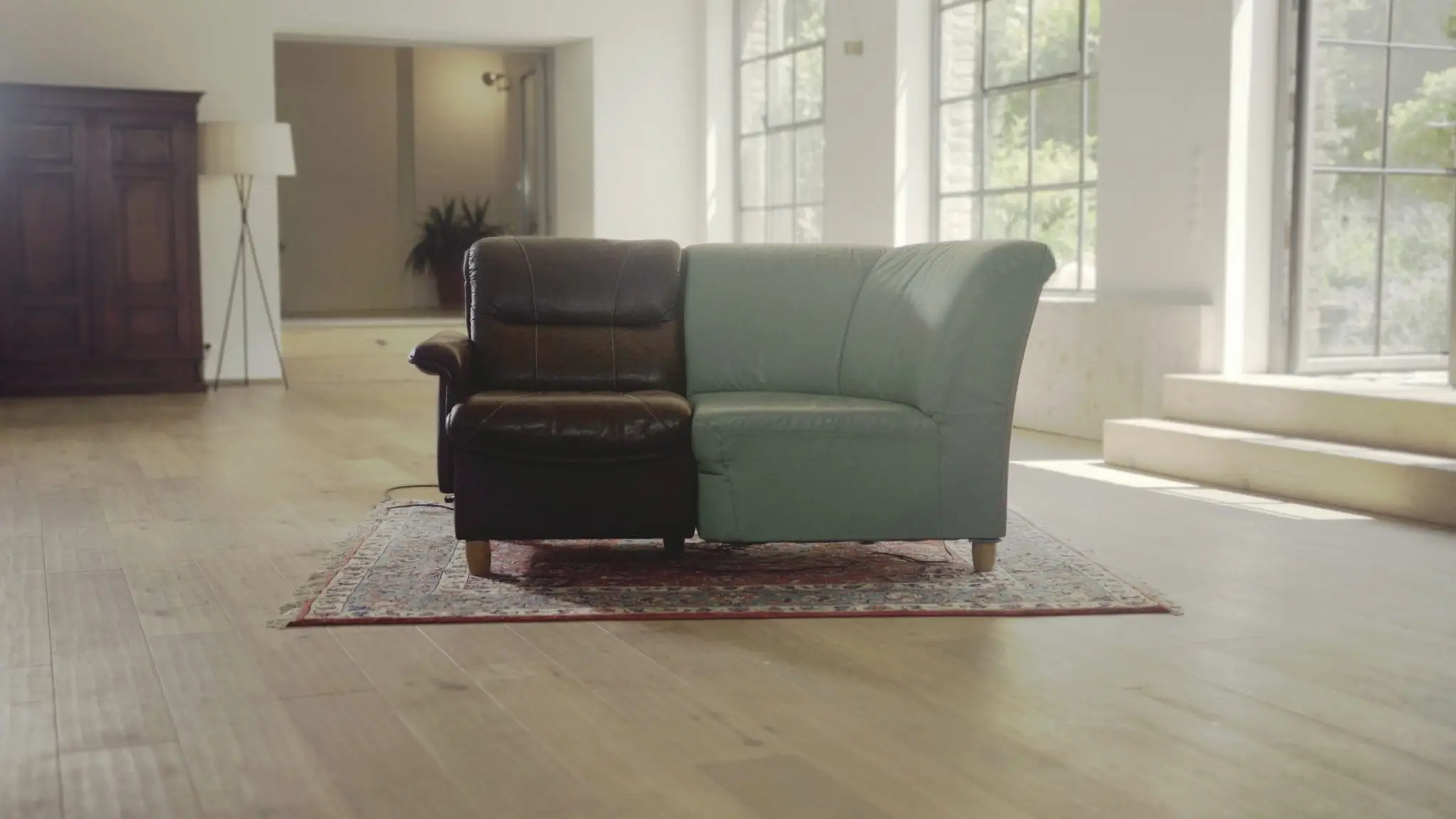 Two halves of different sofas, dark leather and green, joined into one