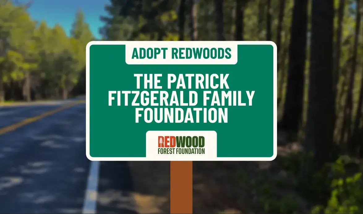 An Adopt Redwoods roadside sign naming a donor family